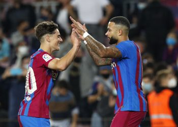 Penyerang Barcelona, Memphis Depay (kanan) merayakan gol ke gawang Valencia bersama Gavi dalam laga Liga Spanyol 2021/2022 di Stadion Camp Nou, Senin (18/10/2021). (Foto: REUTERS/Albert Gea)