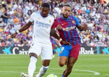 Bek Real Madrid, David Alaba berebut bola dengan penyerang Barcelona, Memphis Depay dalam laga Liga Spanyol di Camp Nou, Barcelona, Minggu (24/10/2021) malam WIB. [Josep LAGO / AFP]
