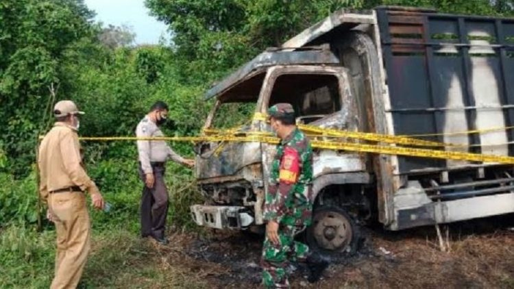 Aparat memasang garis polisi di lokasi truk yang dibakar sekelompok OTK di Jambi. (Foto: istimewa)