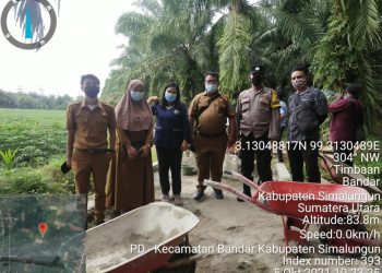 Para Aparatur Desa saat foto bersama di lokasi pembangunan tembok penahan tanah (TPT), di Jalan Sikodok, Huta III, Nagori Landbouw, Kecamatan Bandar, Kabupaten Simalungun, dengan melibatkan 10 orang warga setempat, Selasa (5/10/2021).
