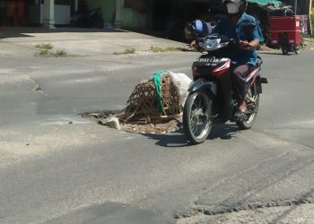 Pengendara roda dua, tampak ekstra hati – hati saat melintasi jalan Rakutta Sembiring Pematangsiantar, tepatnya di kawasan HKBP Martoba yang kondisinya rusak parah, Selasa (19/10/2021).