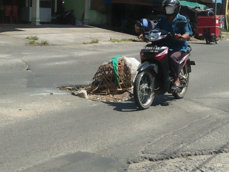 Pengendara roda dua, tampak ekstra hati – hati saat melintasi jalan Rakutta Sembiring Pematangsiantar, tepatnya di kawasan HKBP Martoba yang kondisinya rusak parah, Selasa (19/10/2021).