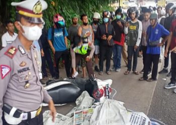 Petugas mengamanan lokasi kecelakaan yang mengakibatkan seorang mahasiswi, Riska Novita Sari (21) tewas terlindas truk usai motornya terlilit kabel WiFi di Jalan Lintas Jambi-Bulian, Muarojambi, Selasa (12/10/2021).