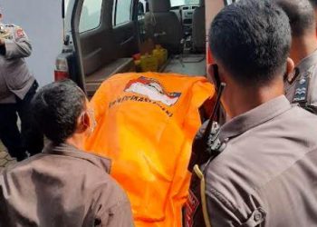 Petugas Polresta Padang mengevakuasi jasad Nelty (56) yang dibunuh kawanan perampok bertopeng, Minggu (24/10/2021). (Foto: MNC Portal/Rus Akbar)