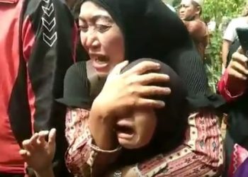 Istri korban, Neli hanya bisa histeris dan memeluk anaknya saat jenazah suaminya dievakuasi ke rumah sakit. Suaminya tewas di tangan bapaknya, Kartadi. Foto: iNewsTV/Uun Yuniar