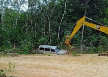 Mobil yang ditumpangi pasangan suami istri terseret banjir hingga masuk sungai di Barito Selatan dan menyebabkan keduanya tewas. (Foto: Antara)