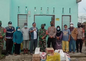 Kapolsek Bangun dan Danramil Model 08 /Siantar foto bersama warga  korban angin puting beliung usai menyerahkan bantuan sembako.