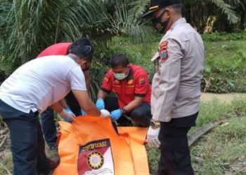 Polisi saat mengevakuasi mayat korban dari lokasi kejadian.