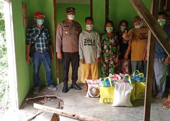 Kapolsek Perdagangan foto bersama warga korban longsor usai menyerahkan bantuan paket sembako.