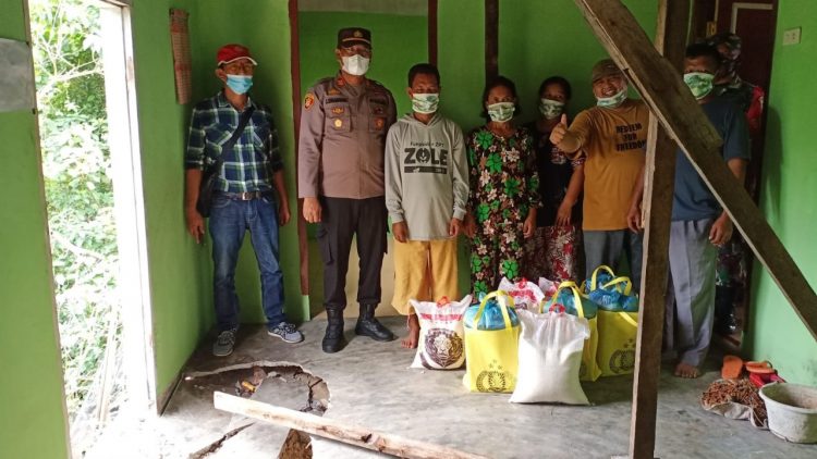 Kapolsek Perdagangan foto bersama warga korban longsor usai menyerahkan bantuan paket sembako.