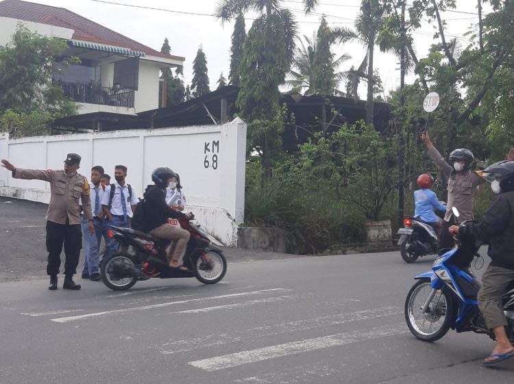 Petugas kepolisian tampak mengatur arus lalu lintas.