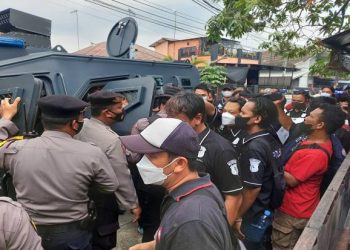 Polisi menjaga ketat jalannya rekontruksi pembunuhan pemilik Rumah Makan Padang, di kompleks GOR Panathayuda Kelurahan Nagasari, Kecamatan Karawang Barat, Kabupaten Karawang. Foto/SINDOnews/Nilakusuma