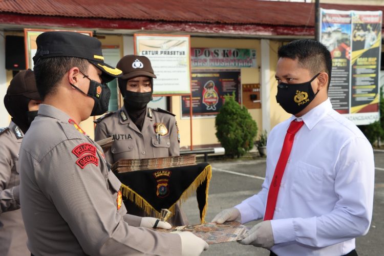 Kapolres Pematangsiantar, AKBP Boy Sutan Binanga Siregar S.I.K, saat memberikan reward (penghargaan,red), kepada 29 personil yang berprestasi, pada Senin (13/12/2021)  pagi tadi, pukul 08.00 WIB, di Lapangan Apel Polres Pematangsiantar.