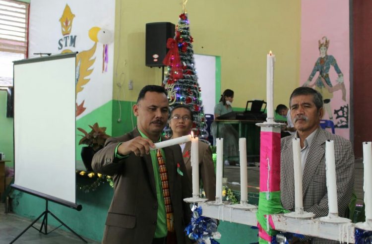 Plt Kepala Sekolah (Kasek) SMK Negeri 2 Pematangsiantar, Bintang Tumanggor SP.d, saat menyalakan lilin.
