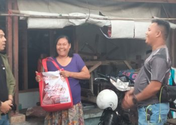 Bane Raja Manalu, pendiri Bane Gas Komuniti (Bagak), saat menyerahkan sembako kepada warga.