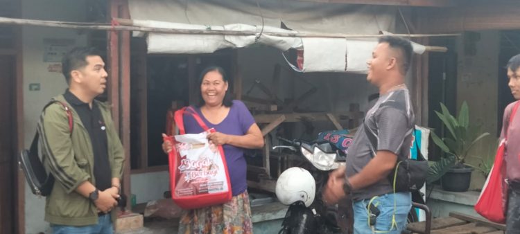 Bane Raja Manalu, pendiri Bane Gas Komuniti (Bagak), saat menyerahkan sembako kepada warga.