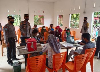 Kapolsek Bangun, AKP LS Gultom SH, tetap semangat melaksanakan kegiatan vaksinasi, di Kantor Pangulu Nagori Huta Dipar, Kecamatan Gunung Maligas, Kabupaten Simalungun, pada Selasa (21/12/2021) pagi tadi, pukul 09.00 WIB.