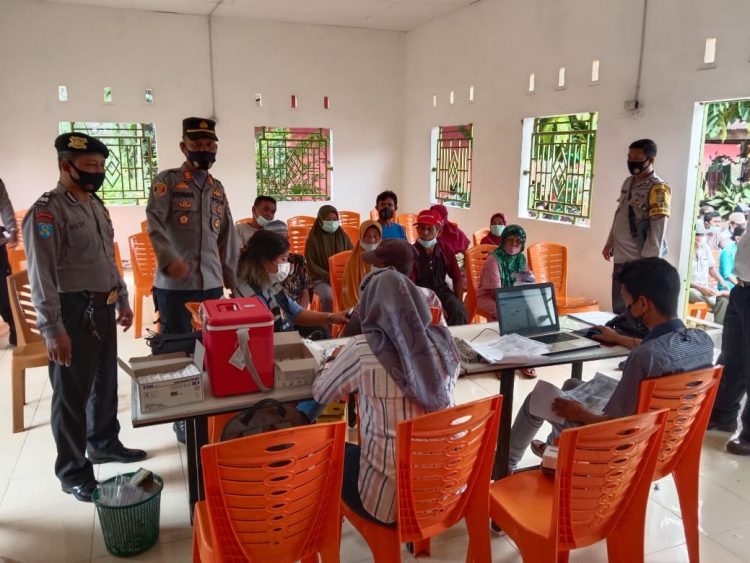 Kapolsek Bangun, AKP LS Gultom SH, tetap semangat melaksanakan kegiatan vaksinasi, di Kantor Pangulu Nagori Huta Dipar, Kecamatan Gunung Maligas, Kabupaten Simalungun, pada Selasa (21/12/2021) pagi tadi, pukul 09.00 WIB.