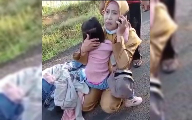 Istri korban begal terus menggendong anaknya di samping suaminya yang terkapar ditembak begal di Lempuing OKI. (Foto: Ist)