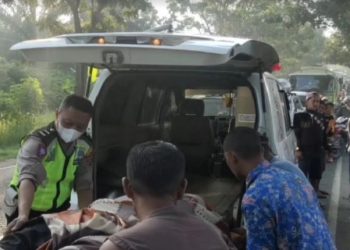 Polisi dan warga mengevakuasi jenazah Muhammad Afrizal Purba (19) setelah motornya menabrak Bus PHM di Jalan Lintas Sumatera, Desa Antara, Limapuluh, Batubara, Sabtu (8/1/2021). Foto/iNews TV/Fadli Pelka