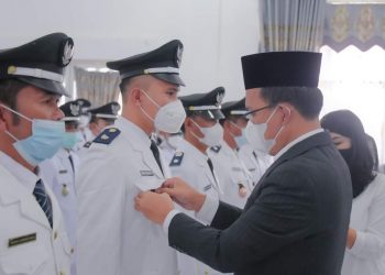 Bupati Humbahas, Dosmar Banjarnahor saat menyematkan tanda jabatan kepada salah satu perwakilan Kades terpilih, Rabu (5/1/2022), di Aula Hutamas Perkantoran Tano Tubu Dolok Sanggul.