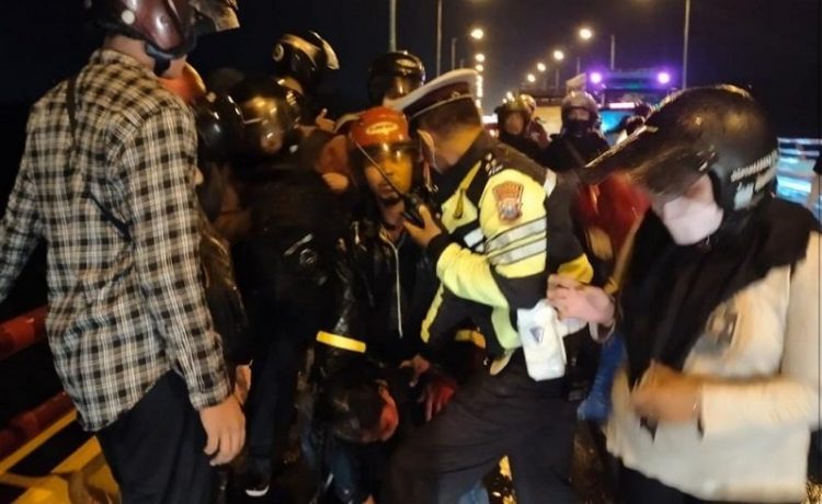 Aparat Polres Kediri mengevakuasi mahasiswi yang mencoba bunuh diri dari atas Jembatan Sungai Brantas, Semampir, Senin (10/1/2022) malam. (istimewa).