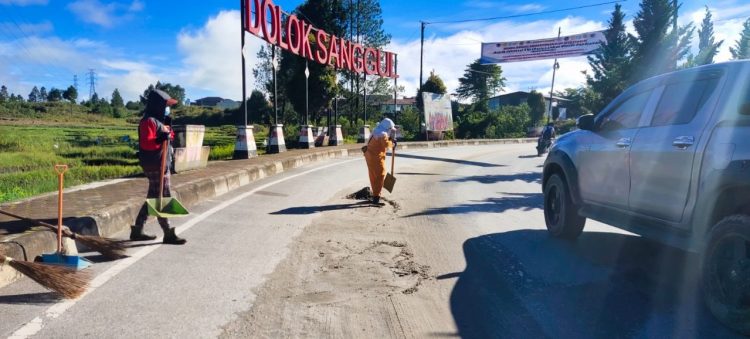 Petugas Kebersihan Dinas Lingkungan Hidup Humbahas tengah membersihkan pasir di jalan. Tampak, menandakan masih rendahnya kesadaran masyarakat akan kebersihan lingkungan.