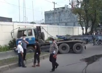Polisi langsung mengamankan lokasi kecelakaan truk yang menewaskan seorang pemotor di Kota Medan. Foto: iNewsTV/Yudha Bahar