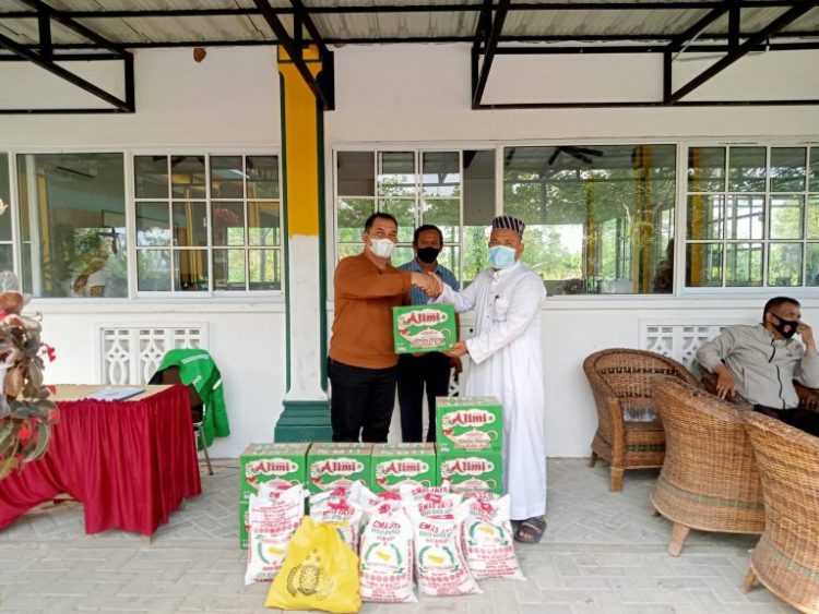 Kapolsek Tanah Jawa, Kompol Selamet Manalu saat  menyerahkan tali asih kepada pengurus pesantren.