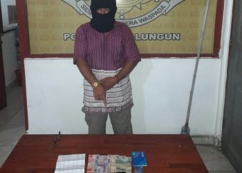 Foto pelaku menunjuk barang bukti judi online.