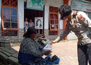 Kasat Lantas Polres Pematangsiantar, AKP Relina Lumbangaol, SSos, saat memberikan nasi kepada warga kurang mampu di Kota Pematangsiantar.