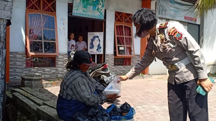 Kasat Lantas Polres Pematangsiantar, AKP Relina Lumbangaol, SSos, saat memberikan nasi kepada warga kurang mampu di Kota Pematangsiantar.
