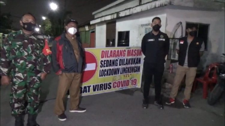 Petugas gabungan menjaga Jalan Mesjid, pintu masuk ke Lingkungan 8, Kelurahan Sei Agul, Medan Barat, Kota Medan. (FOTO: iNews/ADI PALAPA HARAHAP)