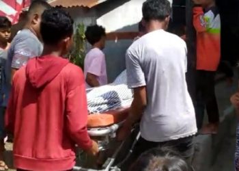 Petugas dibantu warga mengevakuasi jenazah Legino yang tewas ditikam besannya, MY di Kuala Indah, Sei Suka, Batu Bara, Sumatera Utara. Foto/iNews TV/Fadli Pelka