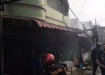 Petugas pemadam kebakaran naik ke atas lantai dua ruko yang terbakar. [Ist]