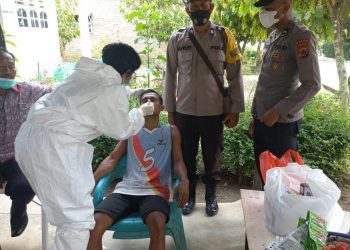 Bripka Lambas Simamora, mendampingi tenaga kesehatan (Nakes) Kecamatan Siantar saat melacak kontak erat atau tracing contact dari warga yang terkonfirmasi positif virus corona atau Covid-19, di Huta IV, Kamis (17/02/2022).