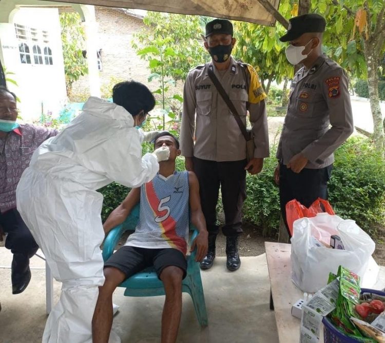 Bripka Lambas Simamora, mendampingi tenaga kesehatan (Nakes) Kecamatan Siantar saat melacak kontak erat atau tracing contact dari warga yang terkonfirmasi positif virus corona atau Covid-19, di Huta IV, Kamis (17/02/2022).