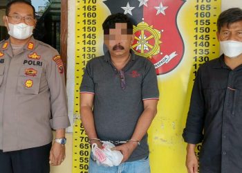 Foto pelaku Hakim diapit petugas.