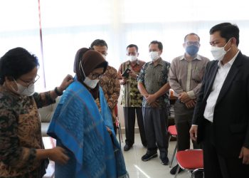 Ephorus GKPS memberikan hiou dengan selempang Simalungun kepada dr. Hj. Susanti Dewayani.