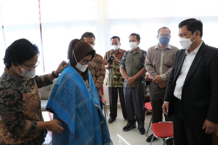Ephorus GKPS memberikan hiou dengan selempang Simalungun kepada dr. Hj. Susanti Dewayani.