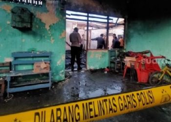 Kebakaran rumah merenggut satu korban jiwa dipasang garis polisi. [Suara.com/M.Aribowo]