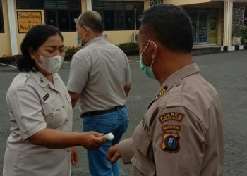 Sidokkes Poliklinik Polres Pematangsiantar, Selfi Diana Sinaga saat memeriksa suhu tubuh para personil dan masyarakat yang berkunjung ke Polres Pematangsintar.