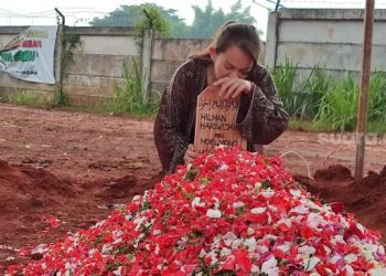 Dewi Natalia tak kuasa membendung air mata usai pemakaman sang suami Hilman Hariwijaya, penulis novel Lupus, di TPU Jombang, Ciputat, Kota Tangerang Selatan (Tangsel), Rabu (9/3/2022). [Suara.com/Wivy Hikmatullah]