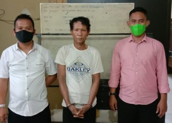 Foto pelaku saat diapit petugas.