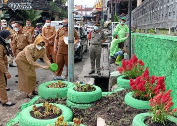 Plt. Wali Kota Pematangsiantar saat menyiram bunga yang baru ditanam di bekas TPSS.