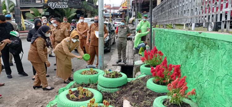 Plt. Wali Kota Pematangsiantar saat menyiram bunga yang baru ditanam di bekas TPSS.