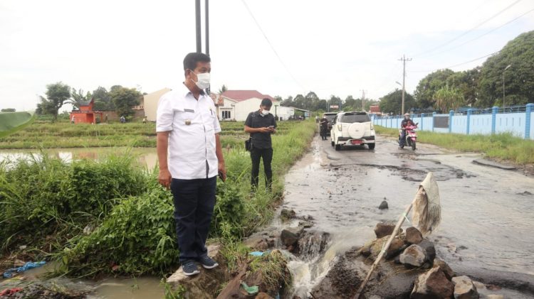 Bupati Simalungun, Radiapoh Hasiholan Sinaga saat meninjau jalan penghubung Siantar-Saribudolok yang rusak.