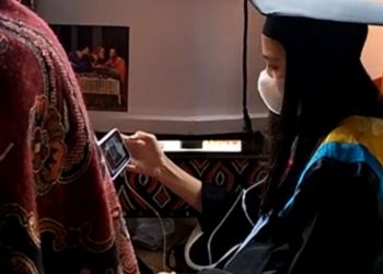 Beredar video viral seorang perempuan muda di TikTok belum lama ini. Dia melakukan wisuda online di depan peti jenazah ayahnya. Foto/TikTok @bepijayanti_amos