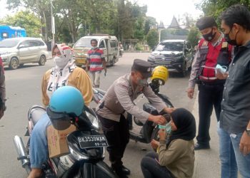 Petugas membagi masker gratis kepada warga.
