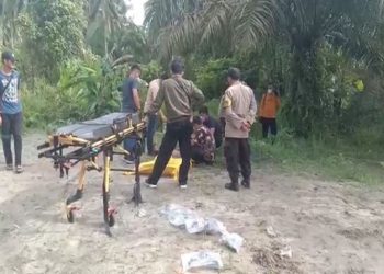Polisi mengevakuasi mayat pria dengan luka tusukan di leher serta dibakar di Kelurahan Kapias Pulo Buaya, Teluk Nibung, Kota Tanjung Balai, Sumut, Rabu (20/4/2022). Foto/iNews TV/Ulil Amri